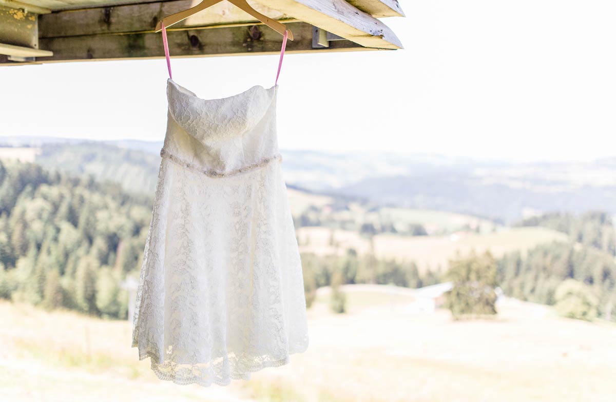 Kurzes Vintage-Spitzenbrautkleid Betty hängt vor Bergkulisse