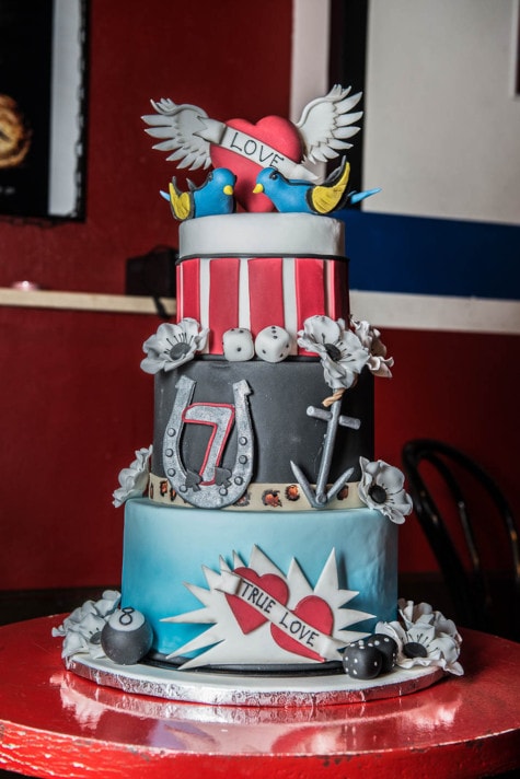 Dreistöckige Hochzeitstorte mit Tattoo-Motiven: Herz mit Flügeln, Schwalben, Hufeisen, Würfel und Lucky 7