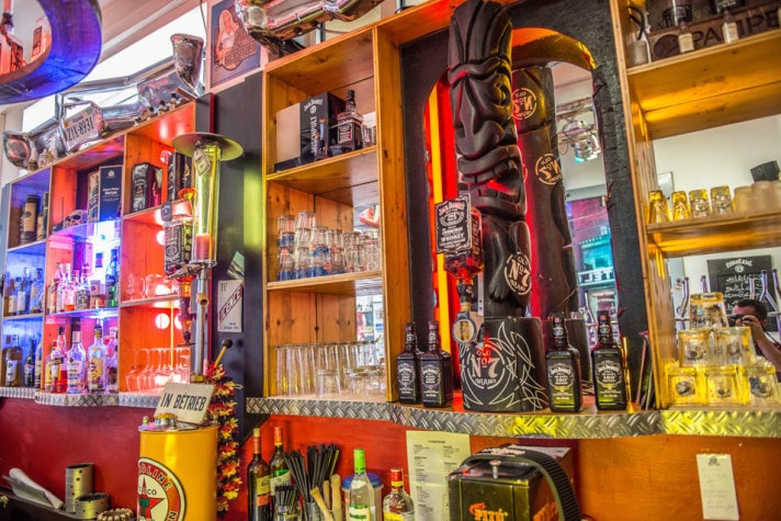 Bunt beleuchtete Bar mit Leuchtreklame und Retro-Deko