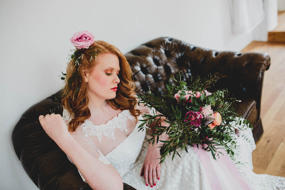 Braut auf Sofa mit Blumen in den Haaren