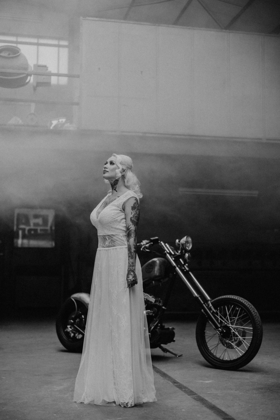 Biker Braut im bauchfreien Brautkleid vor Harley