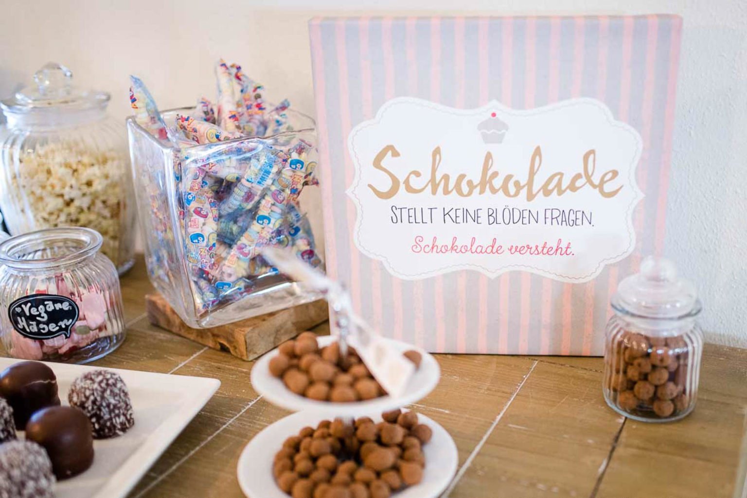 Sweet Table mit Schokolade, Bonbons in Gläsern und einem rosa Schild