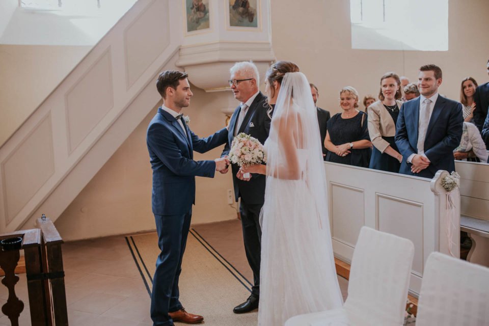 Brautvater übergibt die Braut in der Kirche an den Bräutigam 