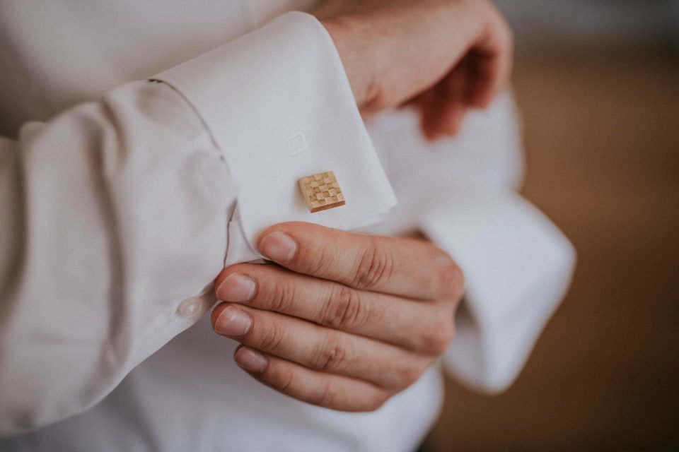 Detailaufnahme vom Bräutigam mit Hemdsärmel und goldenem Manschettenknopf