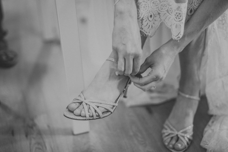 Detailaufnahme von Brautfuß, als sie sich die Schuhe anzieht