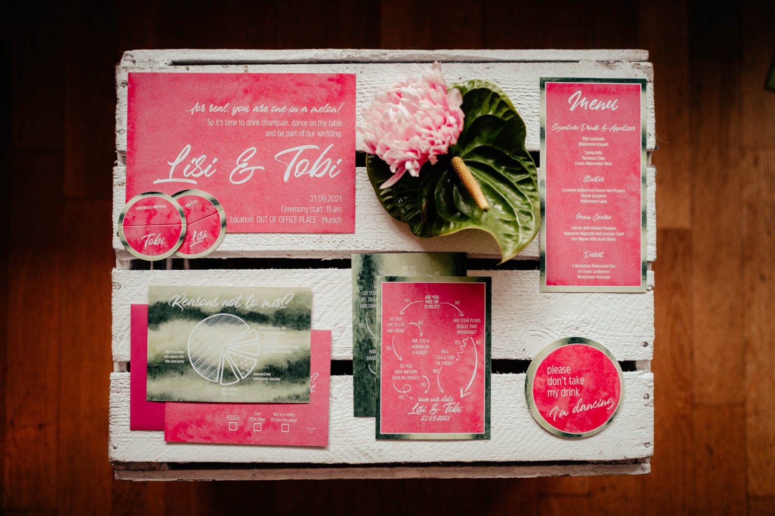 Hochzeitspapeterie in Pink und Grün mit Melonenmotiv auf einer Holzkiste
