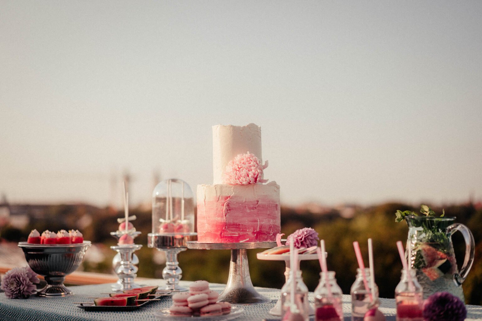 Zweistöckige Hochzeitstorte in Weiß und Pink vor der Skyline