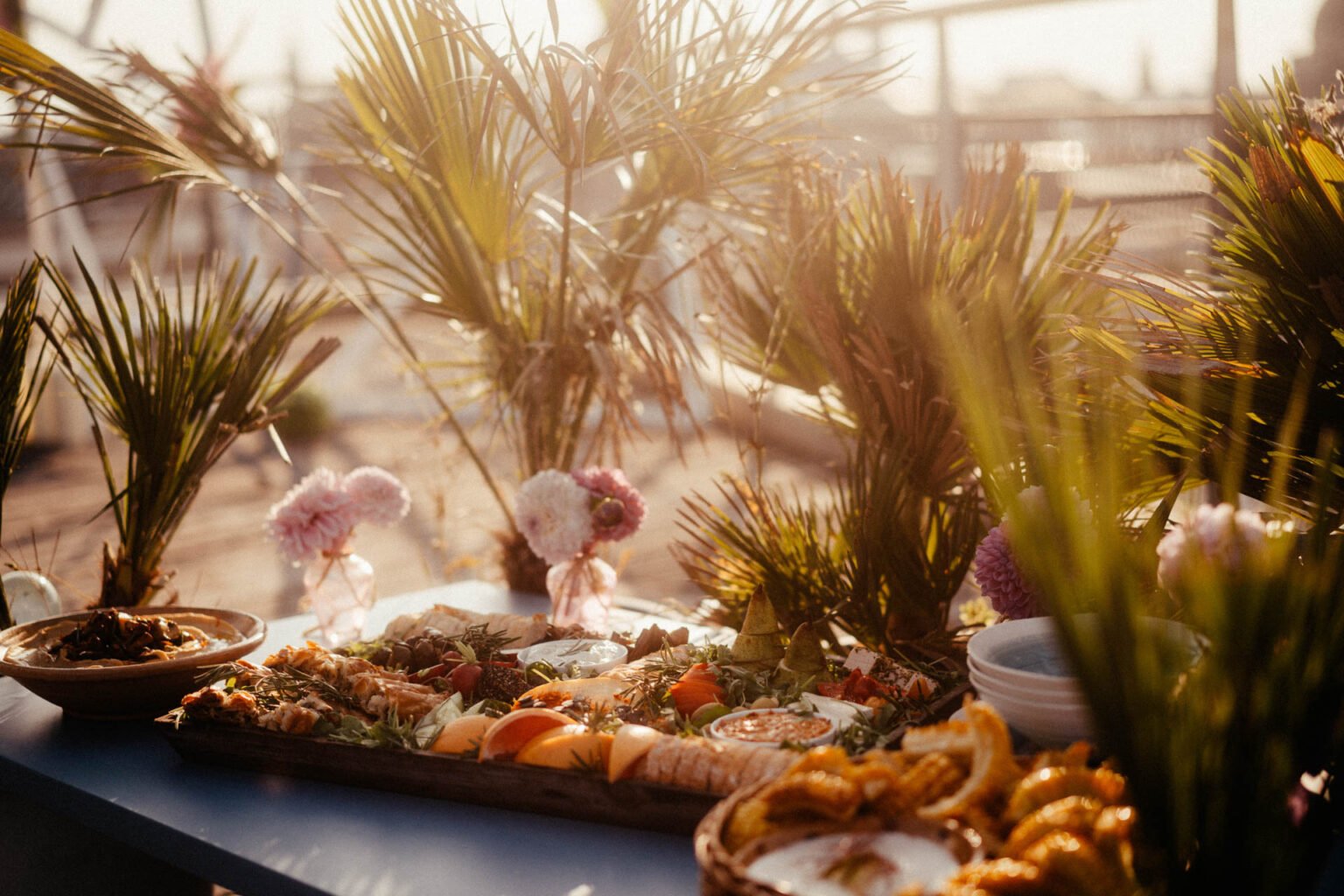 Fingerfood-Buffet zwischen Palmen auf der Dachterrasse