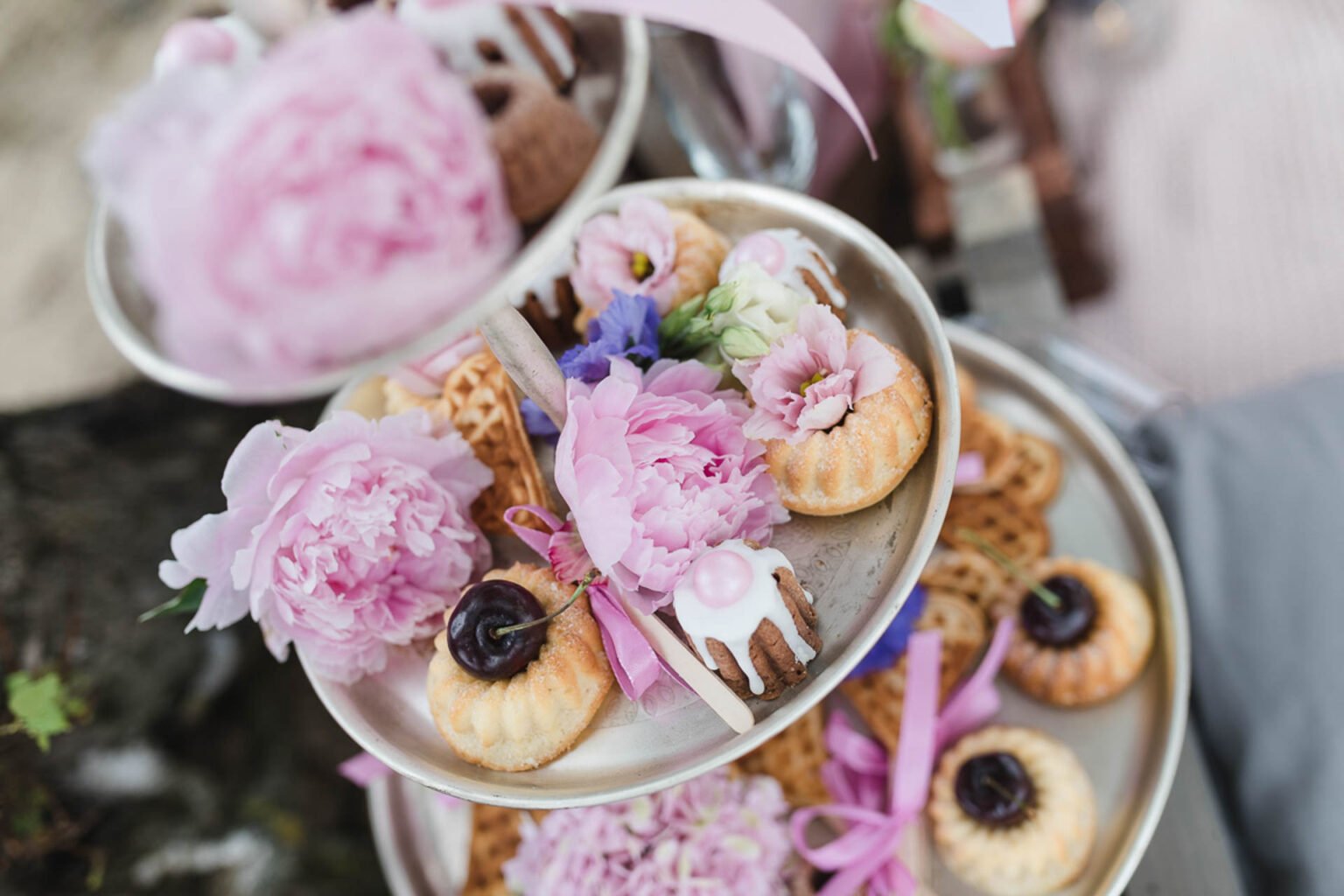 Etagere mit Minigugelhupf, Herzwaffeln und rosa Pfingstrosen