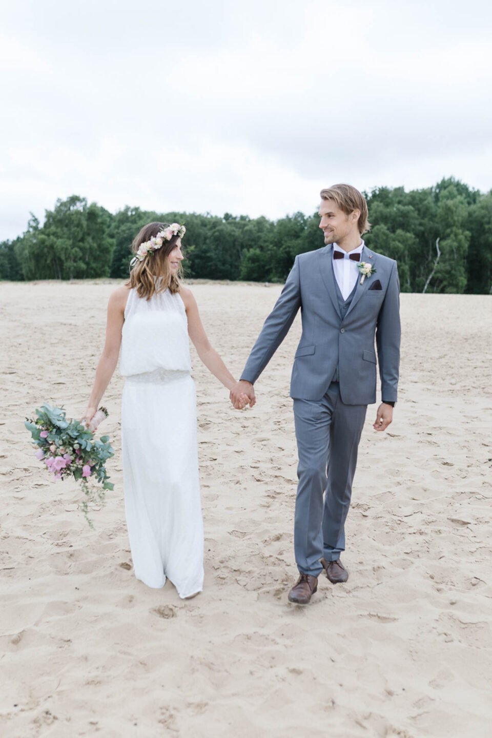 Boho Braut mit BrÃ¤utigam Hand in Hand im Sand