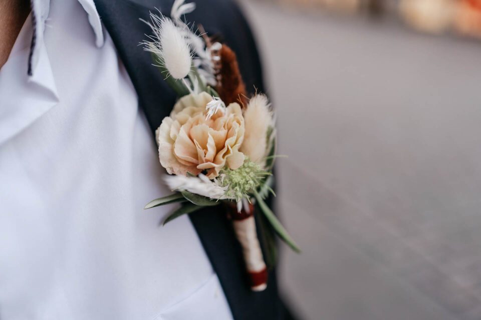 Detailaufnahme Blumenschmuck am Hochzeitsanzug des Bräutigams