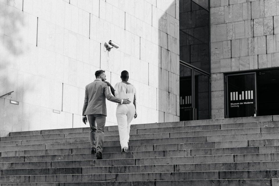 Brautpaar von hinten in Salzburg auf den Treppen des Museums der Moderne in Salzburg