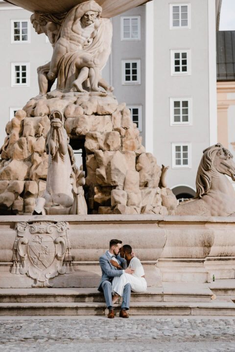Brautpaar sitzt vor Brunnen in Salzburg