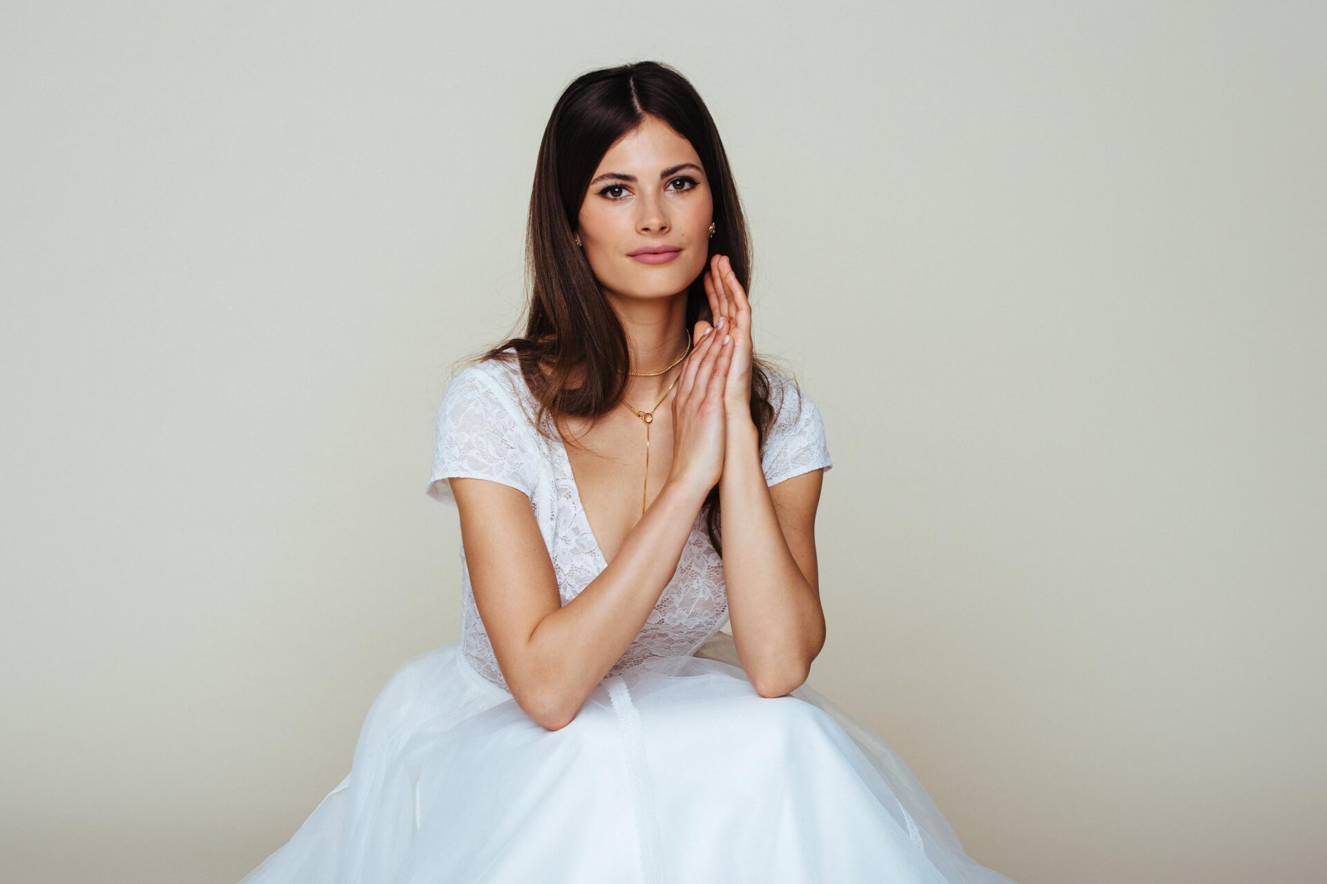 Braut sitzt im Hochzeitskleid mit weitem Tüllrock 