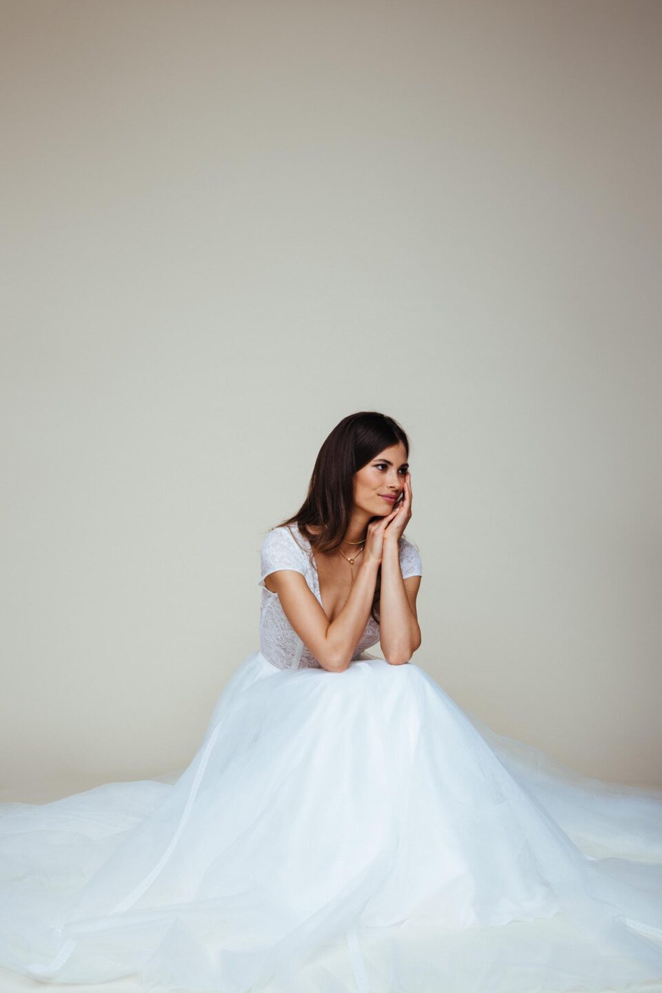 Braut sitzt im Prinzessinnen Brautkleid mit weitem Tüllrock auf dem Boden