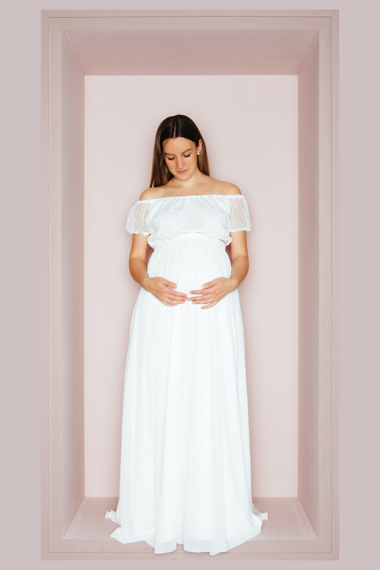 Schwangere Braut im schulterfreien Brautkleid mit Spitzenvolant im Carmen-Stil