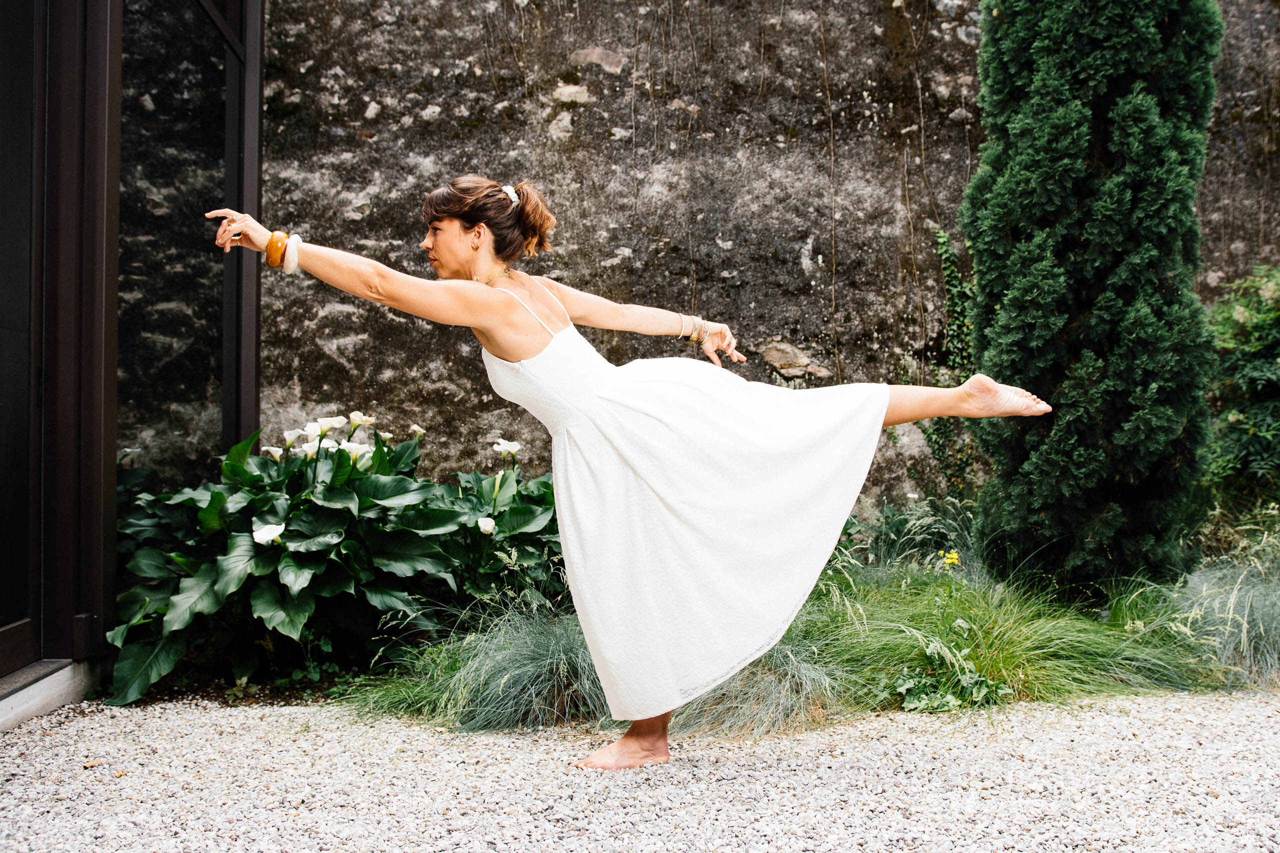 Braut in Tänzerpose im Garten – nachhaltiges GREEN by DESIGN Brautkleid KUESSdieUSTICA aus recycelter Spitze