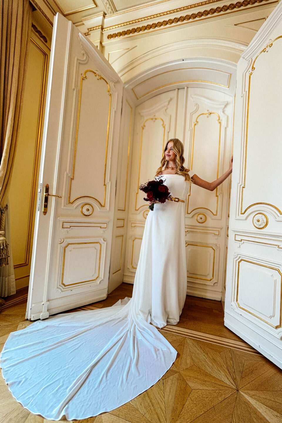 Brautkleid Carlow mit Schleppe in der geöffneten Flügeltür
