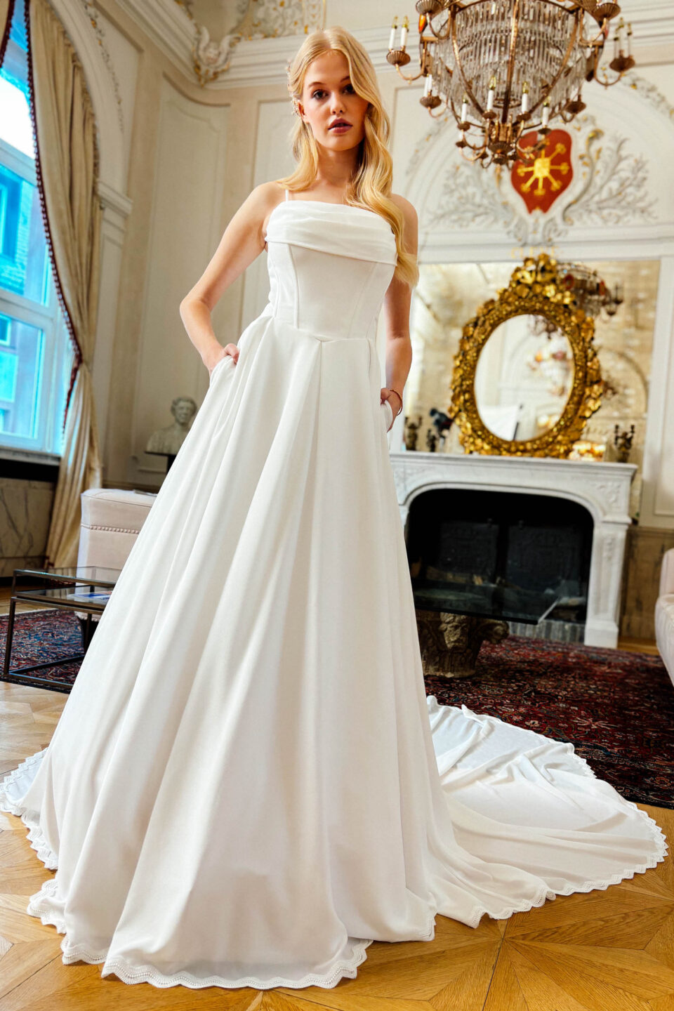Brautkleid Barnsley mit Rocktaschen und Schleppe vor dem Kamin
