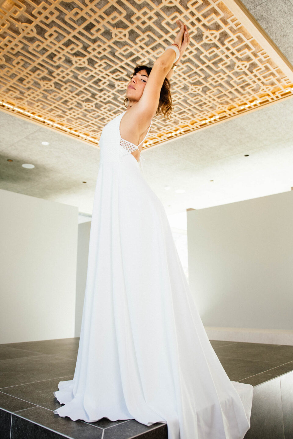 Braut im Boho-Brautkleid KUESSdieAGIRA mit V-Ausschnitt, Spitzenoberteil und fließendem Crêpe-Rock
