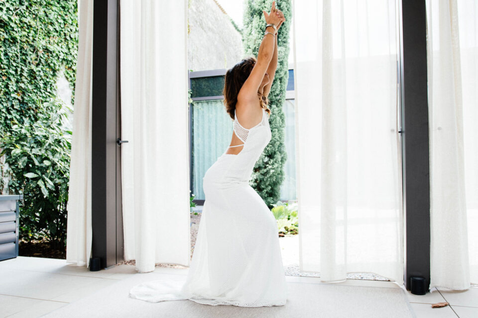 Braut im Fit & Flare Brautkleid Accra in Yoga-Pose, Querformat